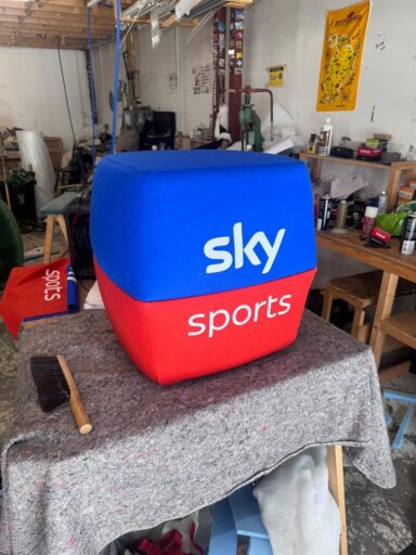 Sky Sports stool upholstered in blue and red Camira fabric